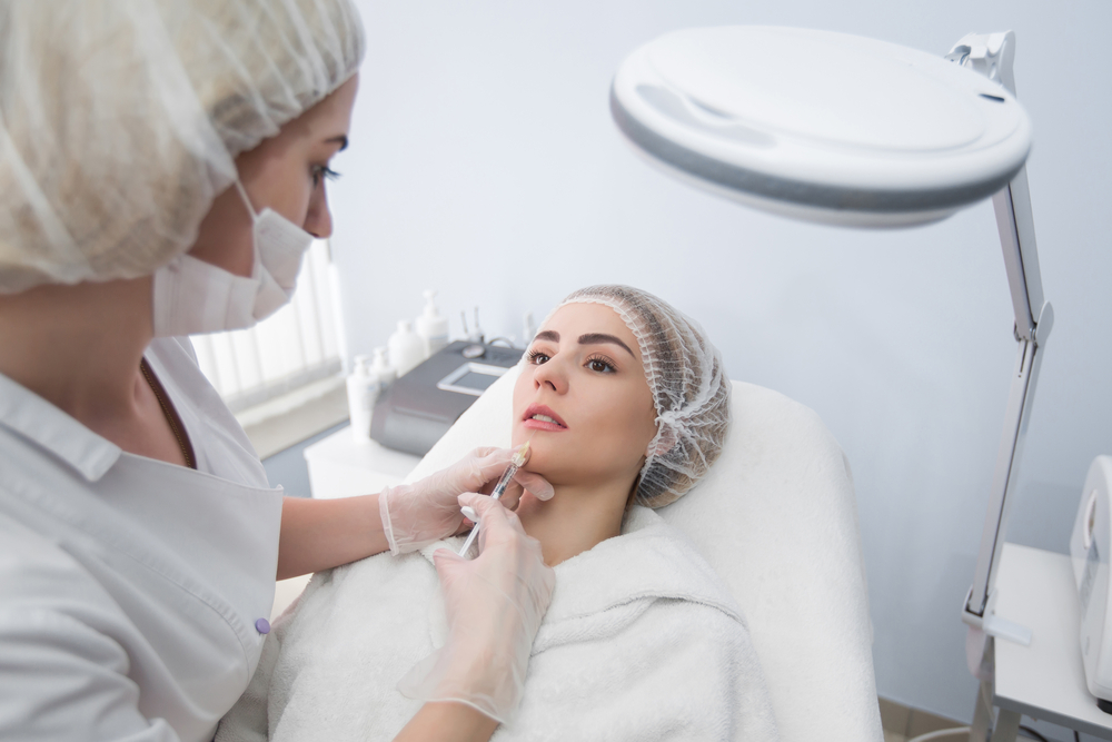 Qualified nurse injector performing BOTOX on female patient