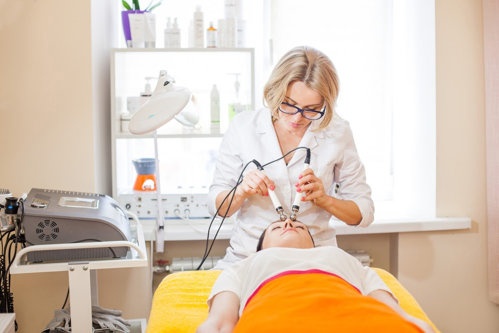 Female medical aesthetic professional providing cosmetic treatment to a patient.