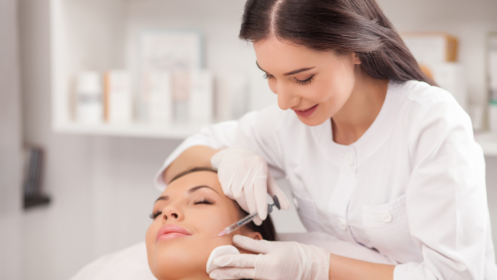 A woman administers a Botox injection
