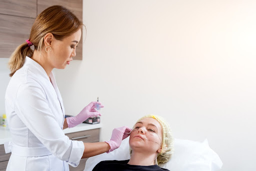 Female cosmetic injector giving Botox to a patient.