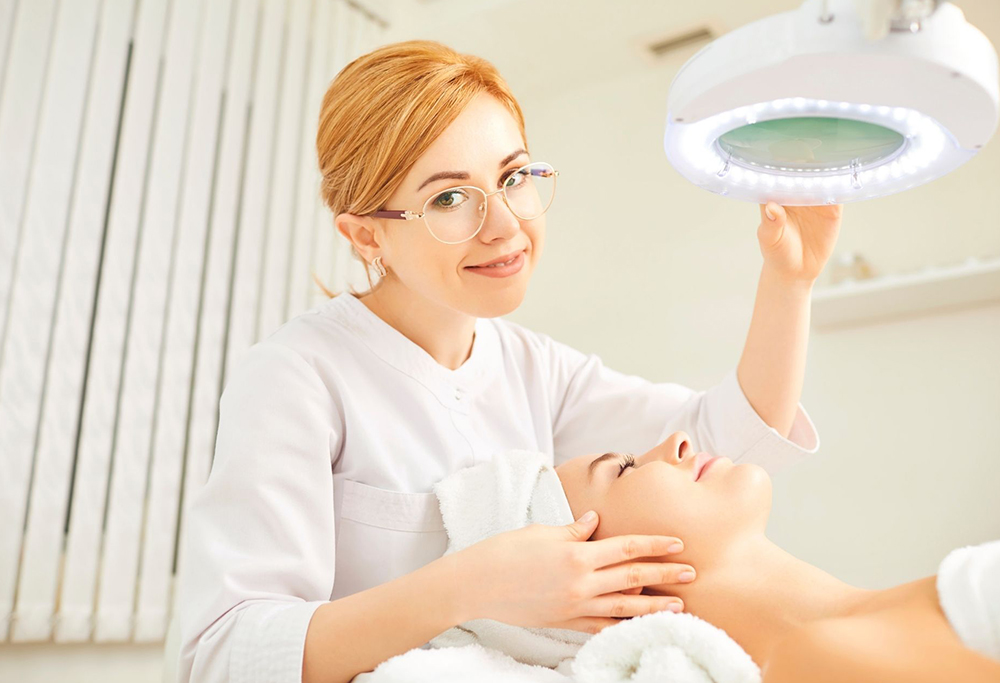 A medical aesthetics professional with a patient