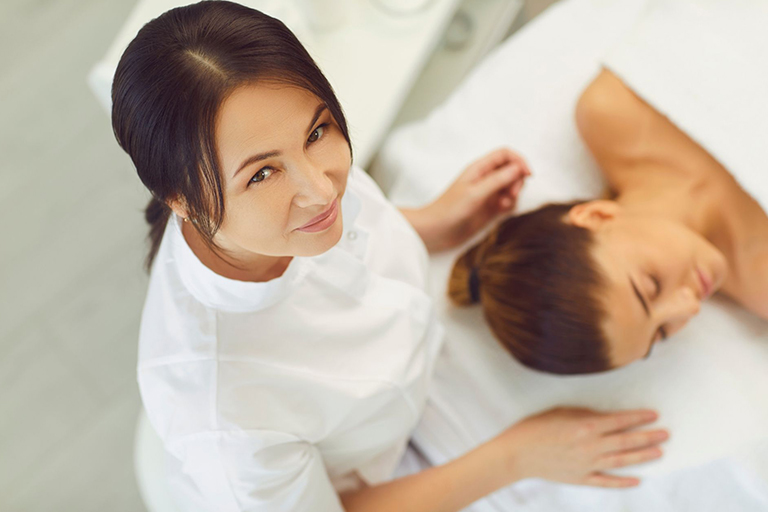 A skin care specialist working on a patient