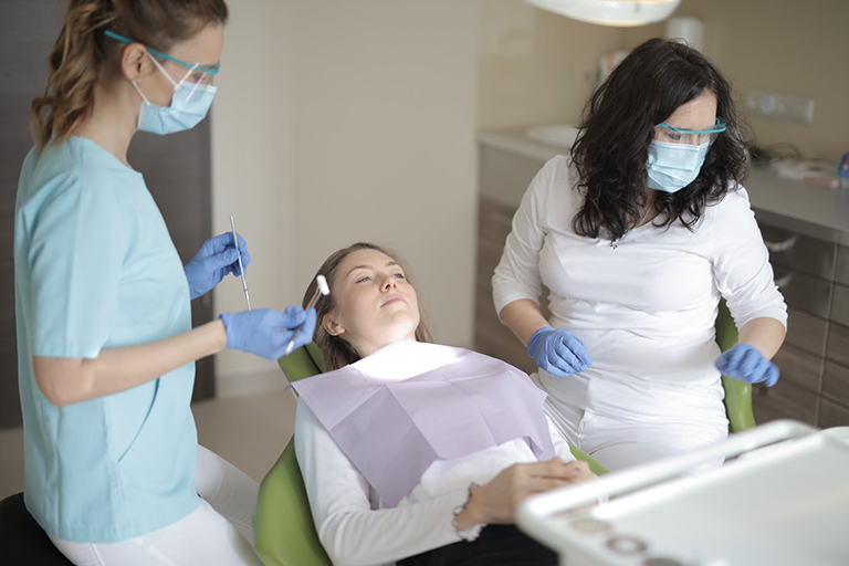 A trainer teaching a student how to inject botox into a live patient model