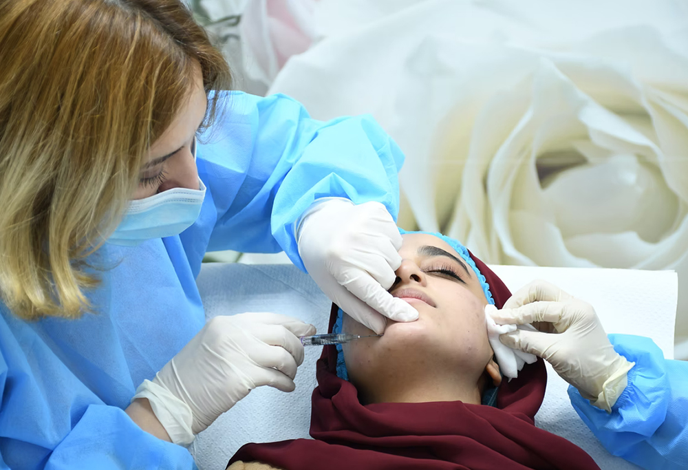 An aesthetician injecting botox into a patient.