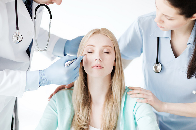 An aesthetic nurse and physician doing a skin assessment on a patient