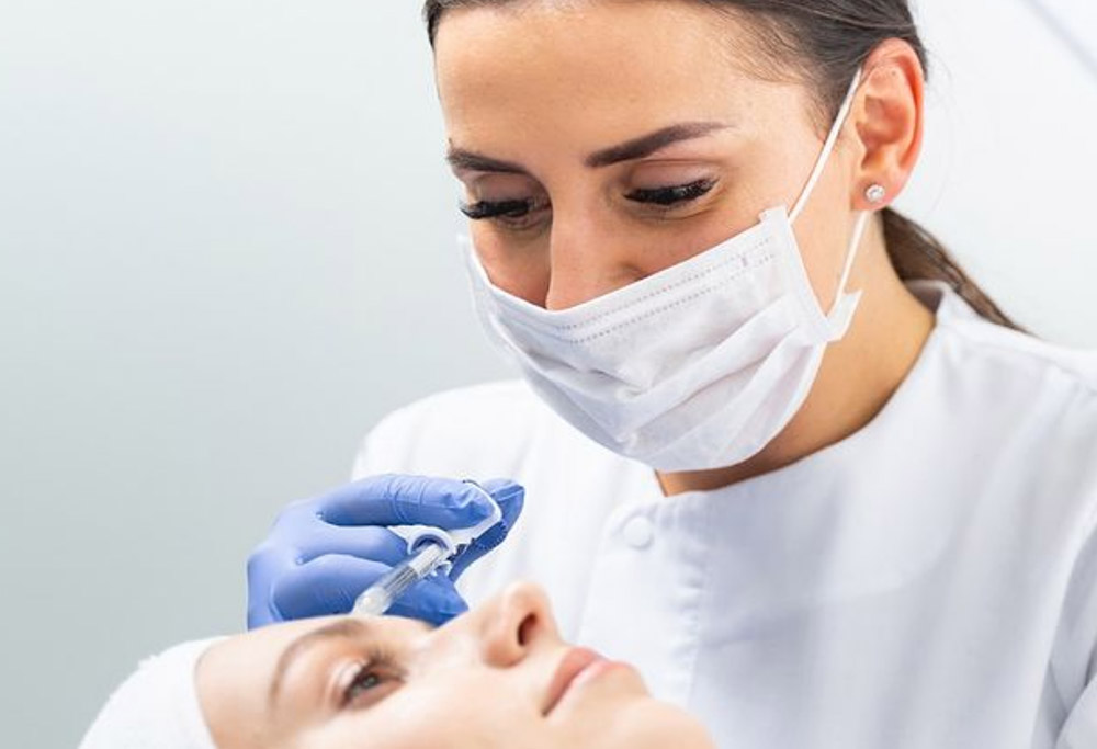 A certified injector giving a female patient a Botox injection