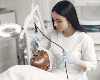 a cosmetic dermatologist treating a patient’s skin issues