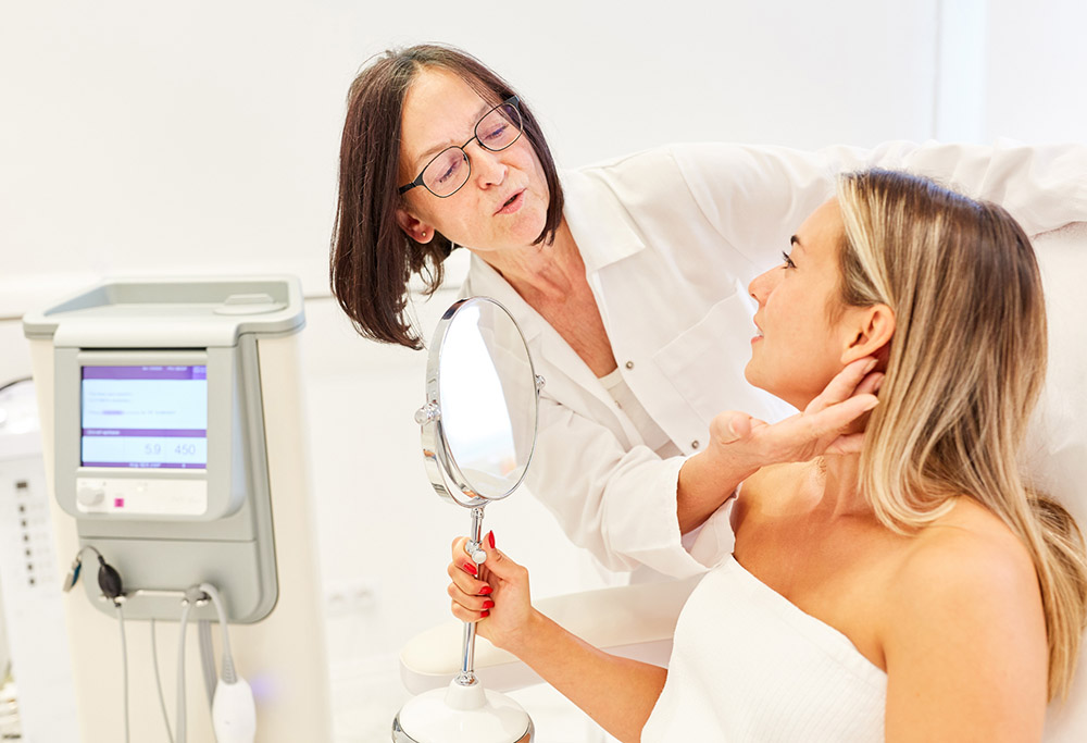 A skincare specialist checks the face of a patient during a consultation in a clinic