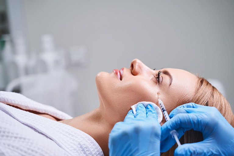 A young woman gets a preventative Botox injection on the side of her eyes