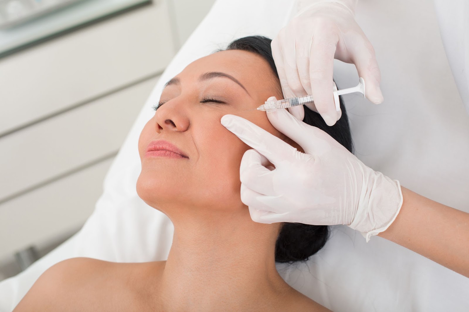 A female patient receives a Botox injection from a medical professional