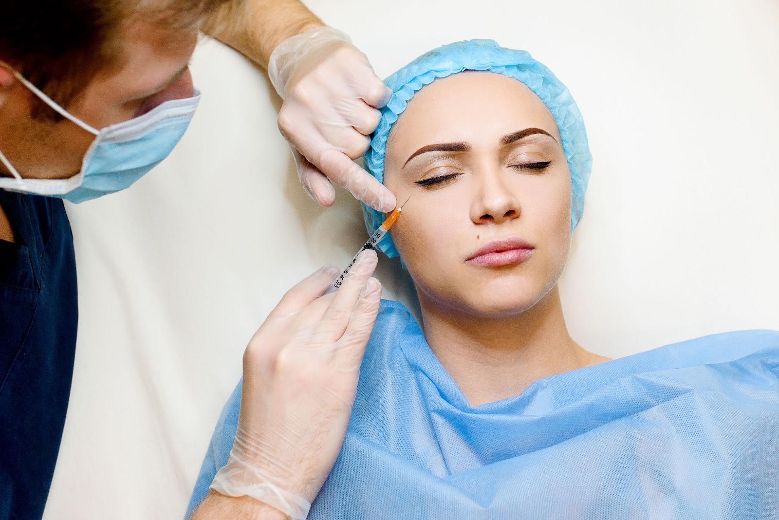 A medical practitioner injects Botox into a patient to treat crow’s feet