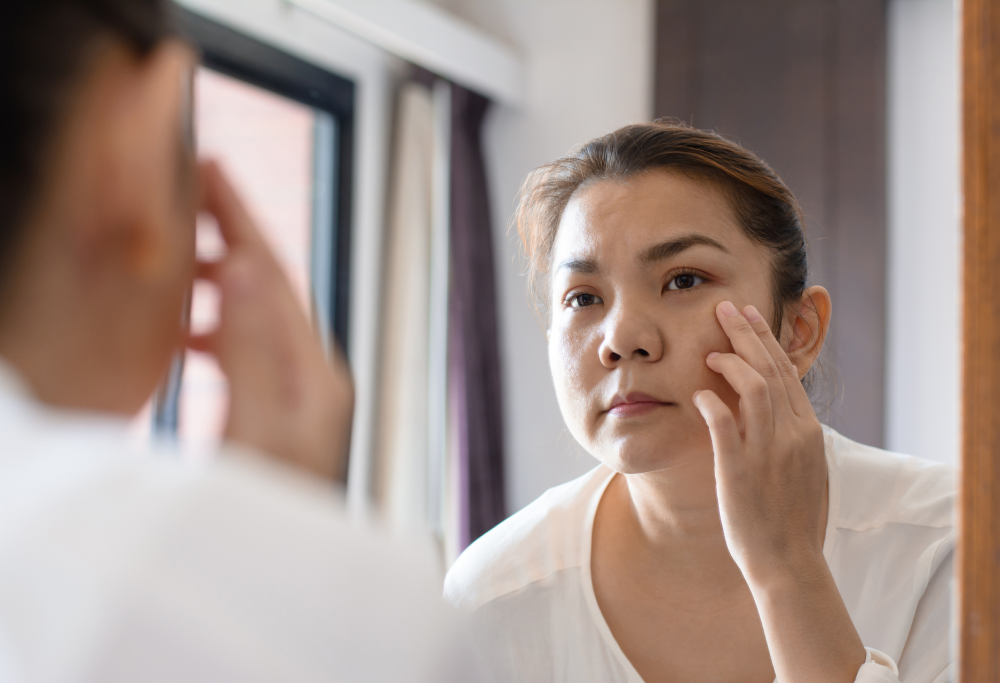 A woman with youthful skin looking in a mirror