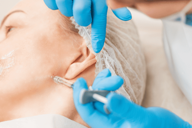 A patient receiving Botox injections for migraines in their jaw by a dentist 