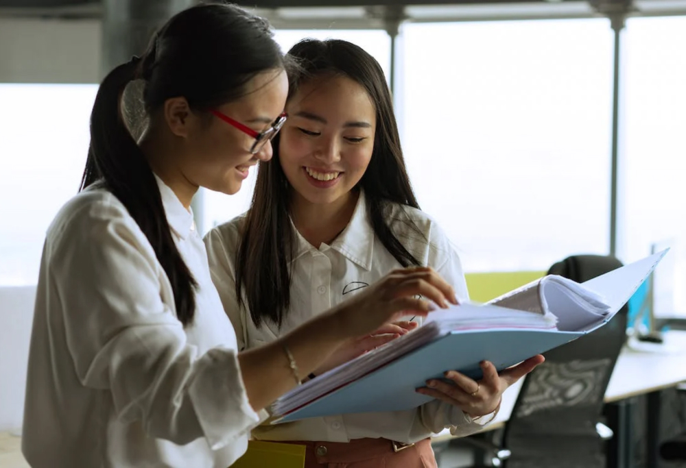 Employees flipping through a policy binder