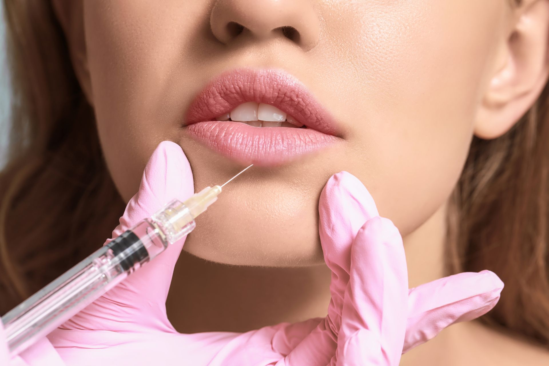 A woman getting a cosmetic injection into her lower lip