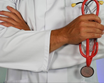 Doctor posing with his arms crossed while holding a stethoscope