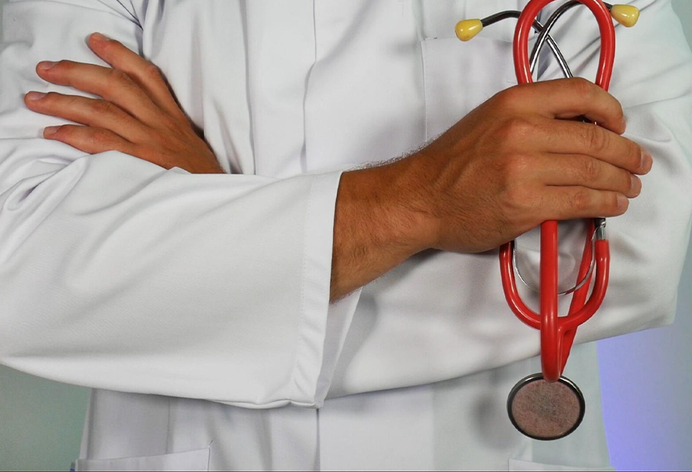 Doctor posing with his arms crossed while holding a stethoscope